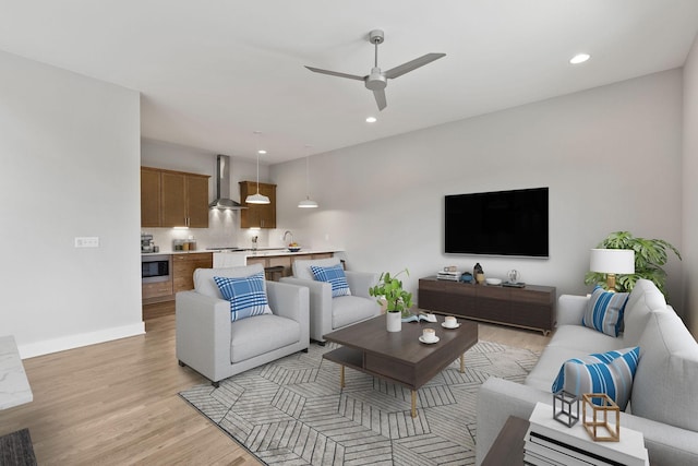 living room featuring ceiling fan and light wood-type flooring