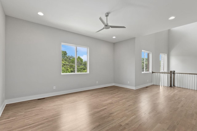 unfurnished room with light hardwood / wood-style flooring, a wealth of natural light, and ceiling fan