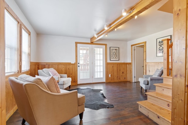 living area with beam ceiling, rail lighting, dark hardwood / wood-style floors, and a healthy amount of sunlight