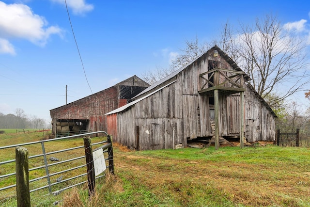 view of outdoor structure featuring a rural view and a lawn