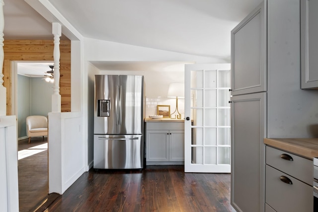 kitchen with gray cabinets, butcher block counters, dark hardwood / wood-style floors, stainless steel refrigerator with ice dispenser, and decorative backsplash