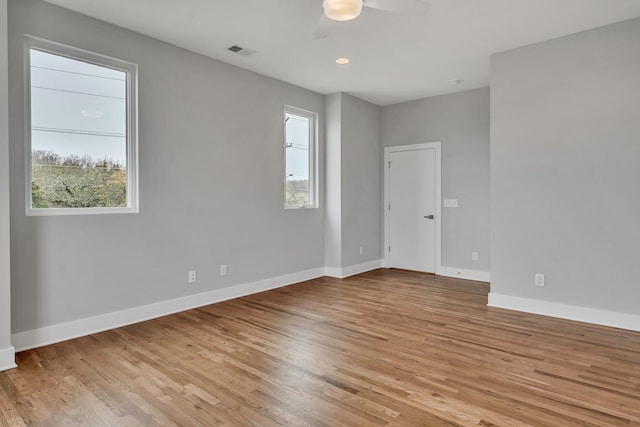 spare room featuring a wealth of natural light, ceiling fan, and light wood-type flooring