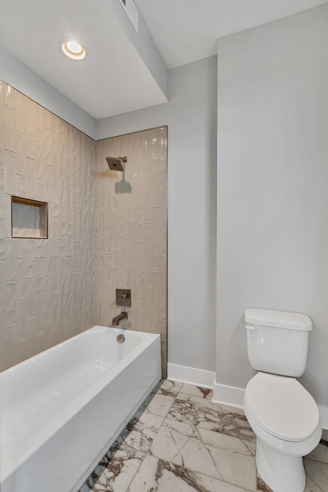 bathroom with toilet and tiled shower / bath combo