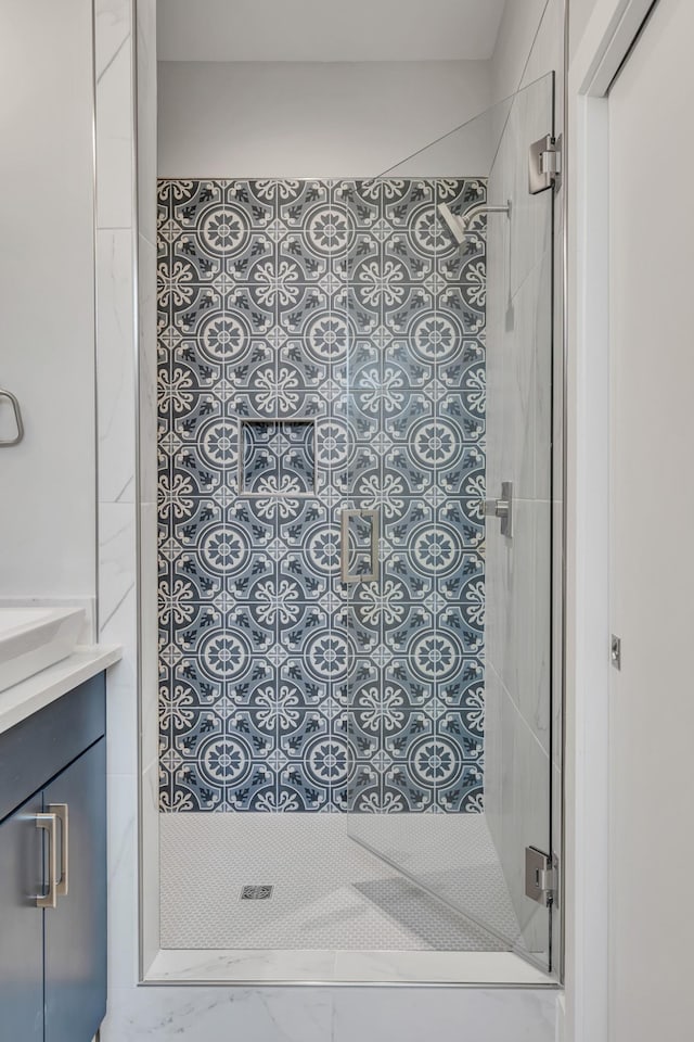 bathroom featuring vanity and a shower with door