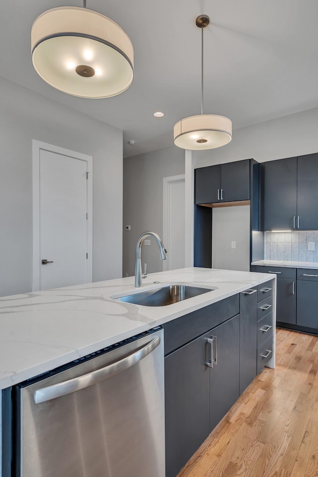 kitchen with pendant lighting, sink, backsplash, stainless steel dishwasher, and light wood-type flooring