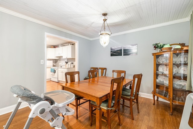 dining space with ornamental molding and light wood-type flooring