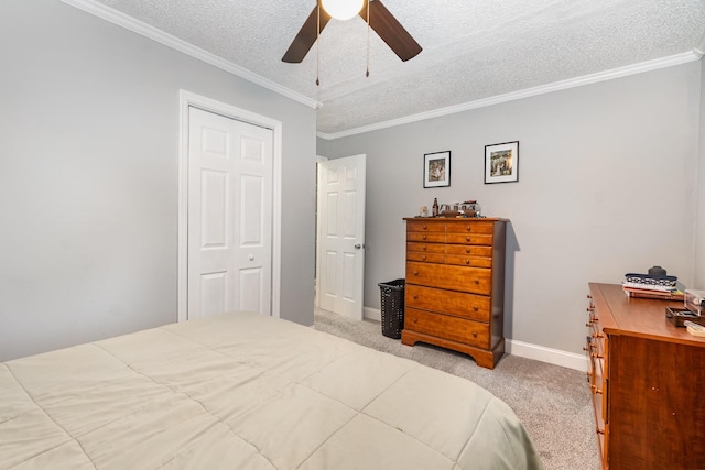 carpeted bedroom with crown molding, ceiling fan, a textured ceiling, and a closet