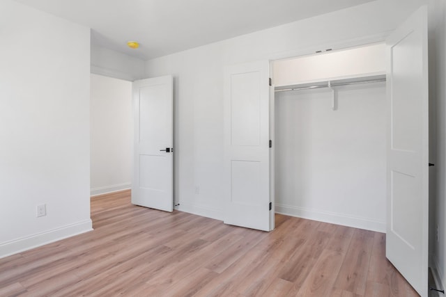 unfurnished bedroom featuring light wood-type flooring and a closet