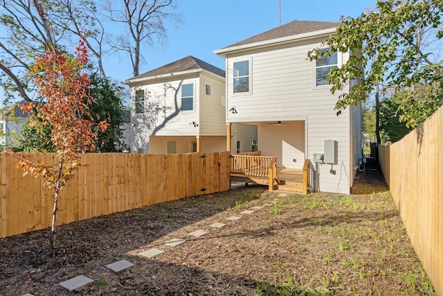 rear view of house featuring a wooden deck