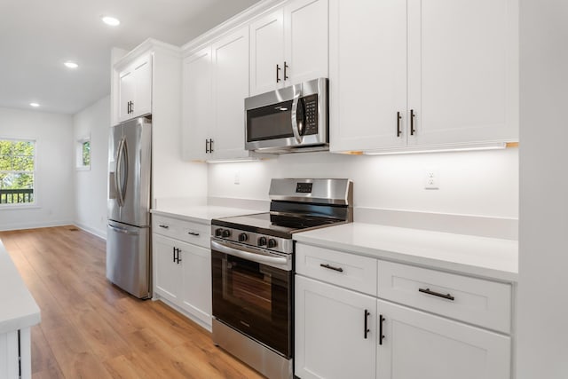 kitchen featuring light hardwood / wood-style floors, white cabinets, and appliances with stainless steel finishes