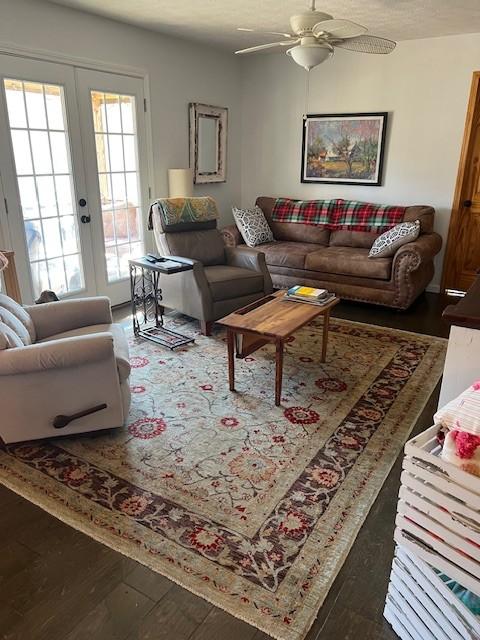 living room with french doors, ceiling fan, dark hardwood / wood-style flooring, and a textured ceiling