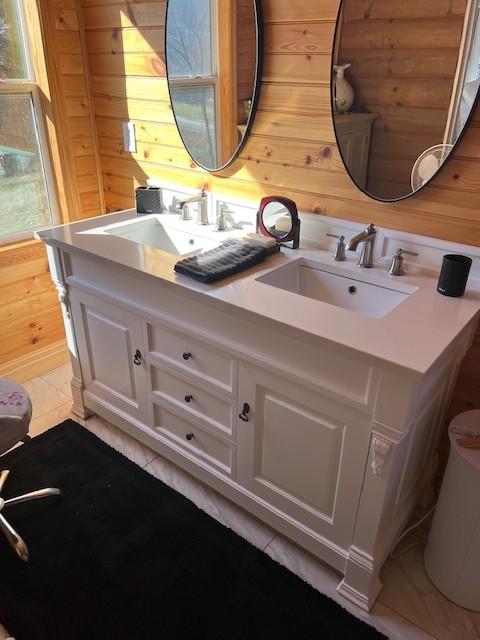 bathroom featuring vanity, tile patterned floors, and wood walls