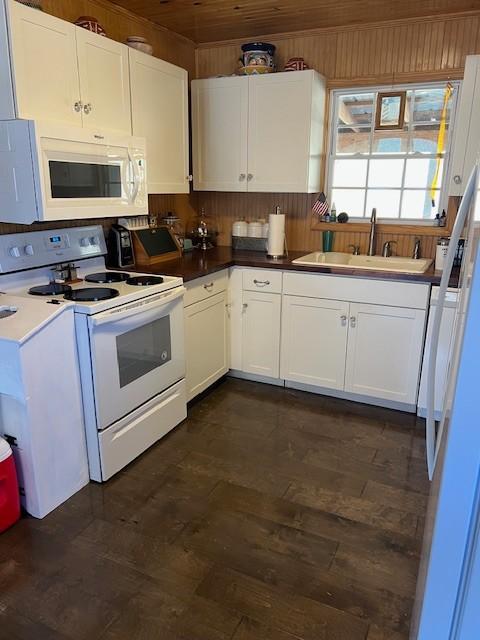 kitchen featuring white appliances, sink, and white cabinets