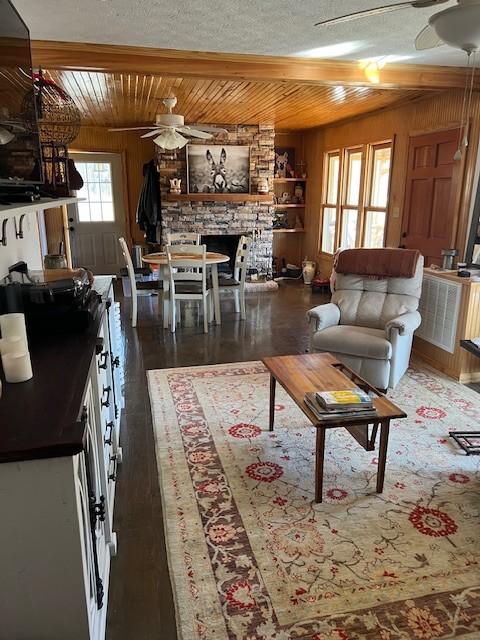 living room with wood ceiling, ceiling fan, dark hardwood / wood-style floors, and wood walls