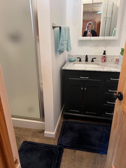 bathroom featuring walk in shower and vanity