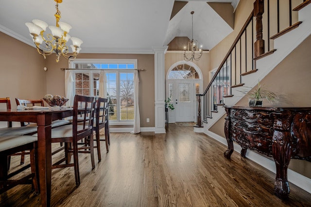 entrance foyer with ornate columns, crown molding, dark hardwood / wood-style floors, and a notable chandelier