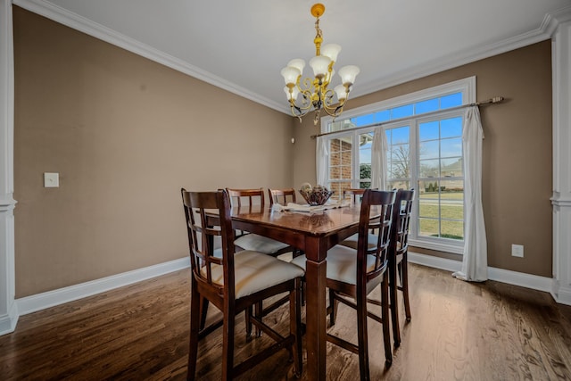 dining room with ornate columns, ornamental molding, dark hardwood / wood-style floors, and a notable chandelier