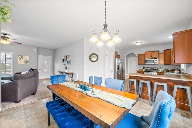 dining room featuring sink and ceiling fan with notable chandelier