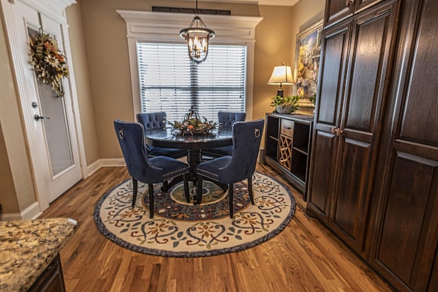 dining space featuring a notable chandelier, baseboards, and wood finished floors