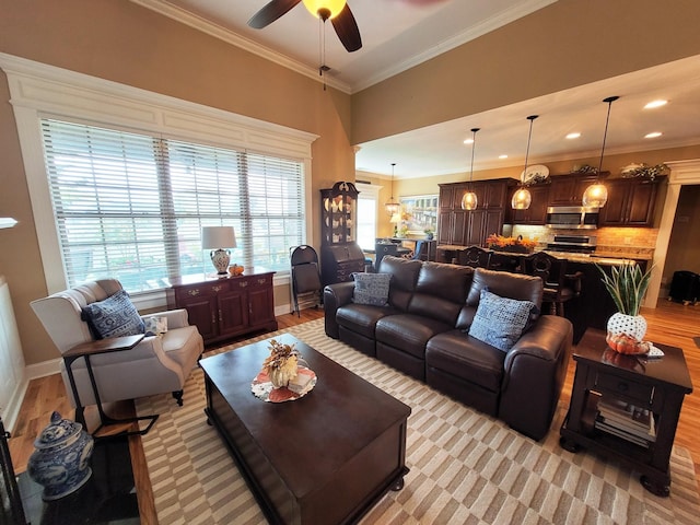 living area with light wood finished floors, baseboards, ceiling fan, ornamental molding, and recessed lighting