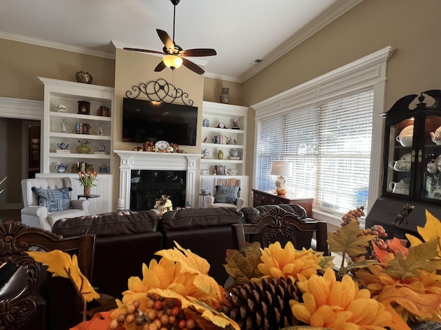 living room with a high end fireplace, ornamental molding, and ceiling fan