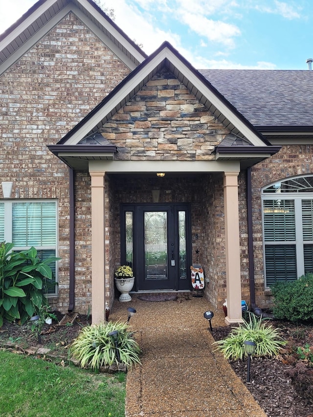 doorway to property featuring roof with shingles, brick siding, and central air condition unit