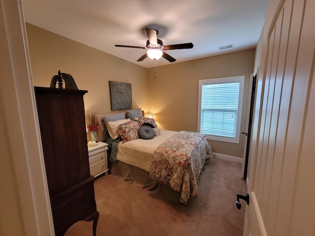 bedroom with ceiling fan, visible vents, baseboards, and light colored carpet