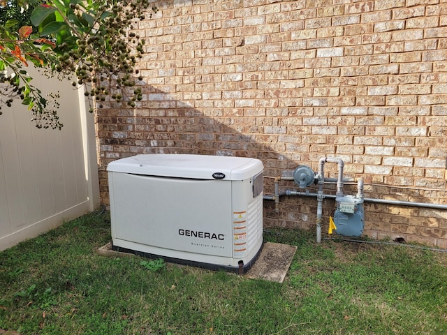 details featuring gas meter, brick siding, and a power unit