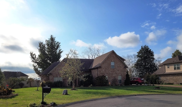 traditional home featuring brick siding and a front lawn