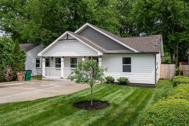 back of house with covered porch and a lawn