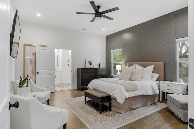 bedroom featuring ceiling fan, wood-type flooring, and connected bathroom