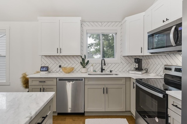 kitchen featuring white cabinetry, appliances with stainless steel finishes, sink, and backsplash