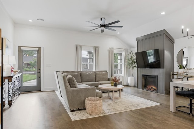 living room with wood-type flooring, plenty of natural light, a large fireplace, and ceiling fan