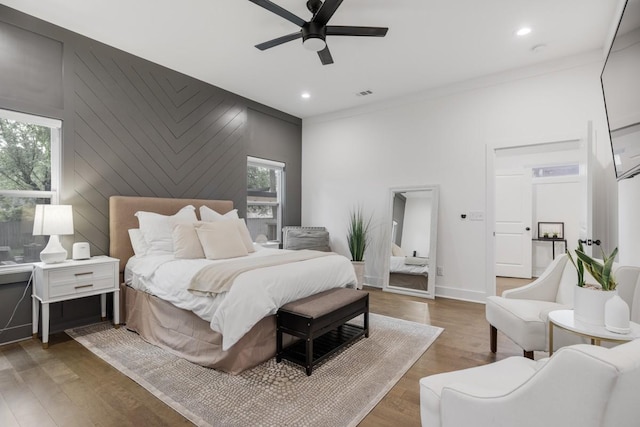 bedroom with ceiling fan, hardwood / wood-style floors, and multiple windows