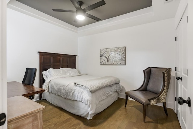 bedroom featuring ceiling fan, a tray ceiling, hardwood / wood-style floors, and a closet