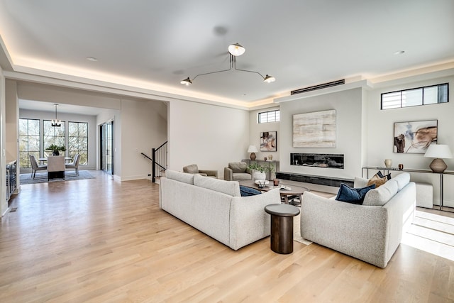 living room with a premium fireplace and light wood-type flooring