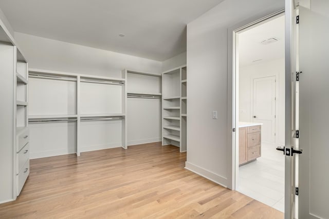 walk in closet with light wood-type flooring