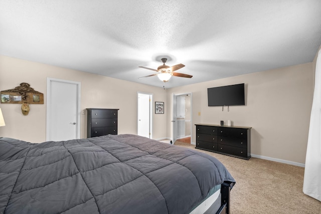 bedroom with ceiling fan, light colored carpet, and a textured ceiling