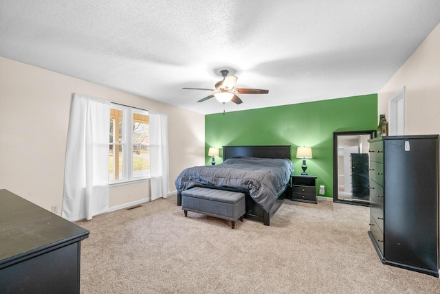 carpeted bedroom featuring ceiling fan and a textured ceiling