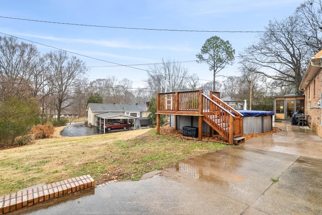 exterior space with a hot tub, a yard, a carport, and a deck