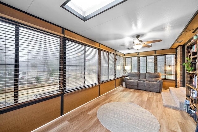 sunroom / solarium with ceiling fan and a skylight