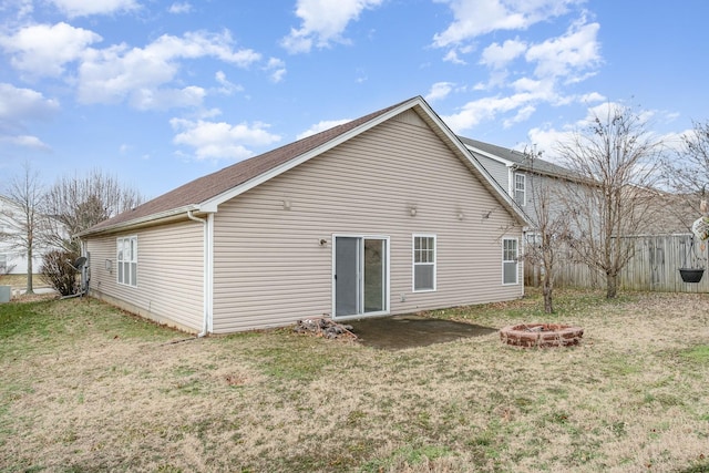 rear view of house featuring a yard and a fire pit