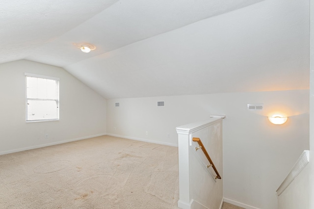 additional living space with light carpet and vaulted ceiling