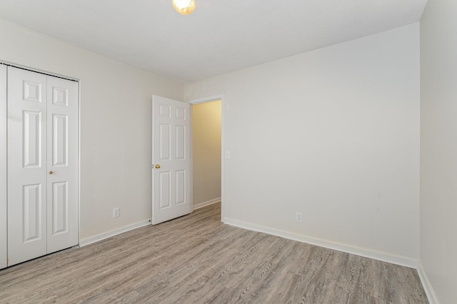 unfurnished bedroom with light hardwood / wood-style flooring and a closet