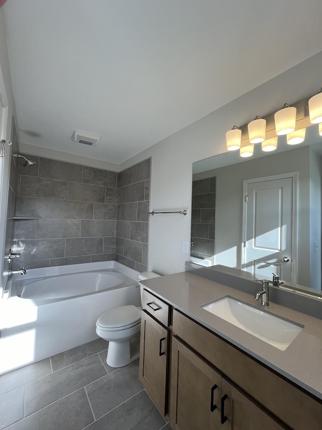 full bathroom featuring tiled shower / bath, vanity, and toilet