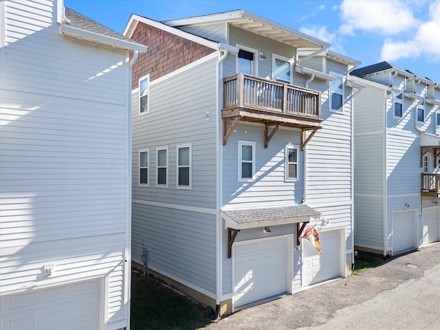 view of side of home featuring a balcony and a garage