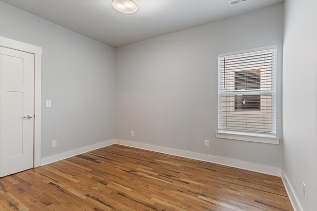 spare room featuring wood-type flooring