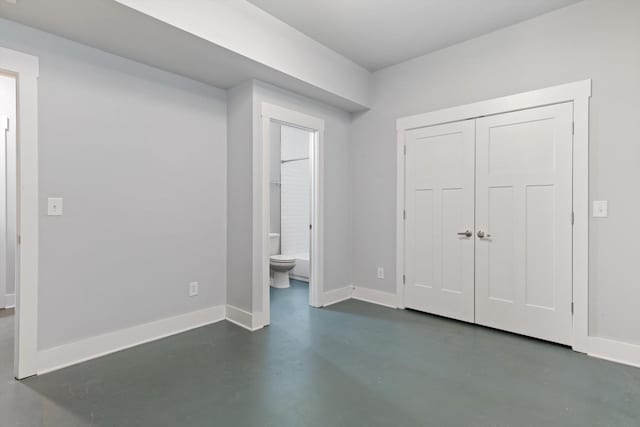 unfurnished bedroom with connected bathroom and a closet