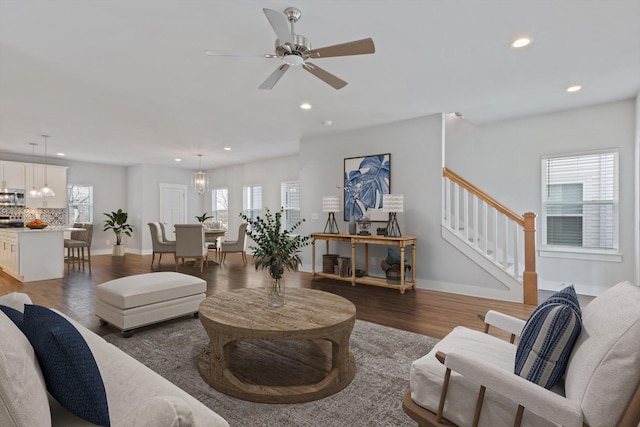 living room featuring ceiling fan and dark hardwood / wood-style flooring