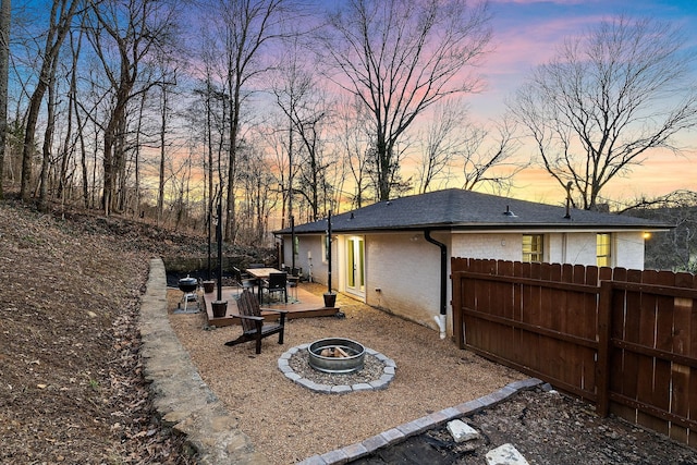 yard at dusk with an outdoor fire pit and a patio area